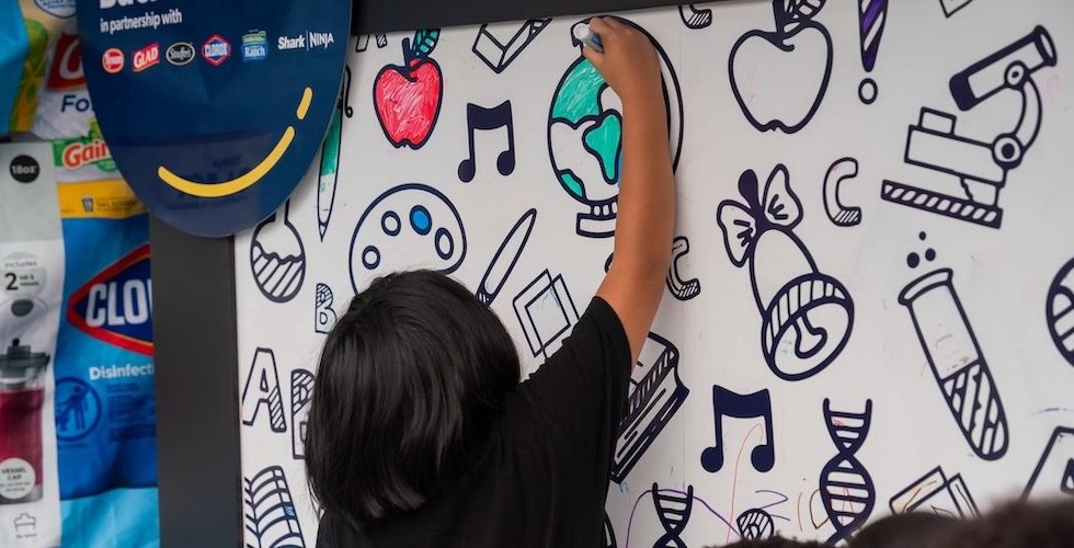 A child is engaged in drawing playful doodles on a wall, illustrating artistic talent and imagination.