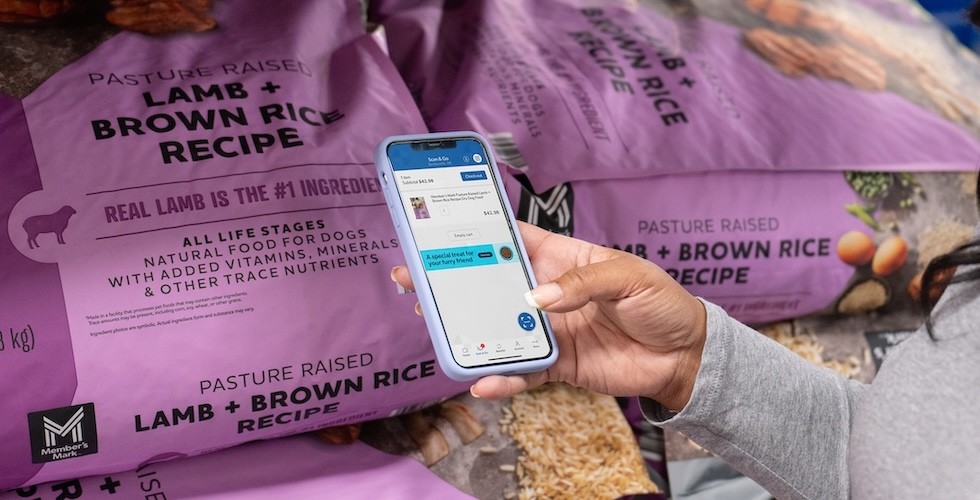 A woman uses the Sam's Club Scan and Go app to scan the barcode on a bag of dog food.